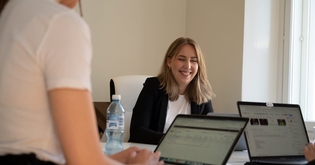 Tiimi työskentelee pöydän ääressä